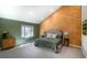 Bright bedroom with wood accent wall, large window, soft carpet, and decorative bedside tables at 6368 S Emporia Cir, Englewood, CO 80111