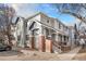 Two-story townhome with a brick foundation and stairs leading to a covered porch at 12943 N Lafayette St # H, Thornton, CO 80241