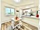Eat-in kitchen featuring stainless steel appliances, white cabinetry and a bright dining area at 8820 Cody St, Broomfield, CO 80021