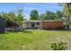 Spacious backyard with lush green grass, mature trees, storage shed, and convenient back access at 1370 S Hudson St, Denver, CO 80222