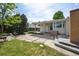 A quaint backyard with a concrete tiled patio, a lush lawn and verdant trees on a sunny day at 1370 S Hudson St, Denver, CO 80222
