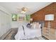 Cozy bedroom with brick accent wall, ceiling fan, and ample natural light from two windows at 1370 S Hudson St, Denver, CO 80222