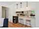 Eat-in kitchen bar with stylish stools connecting to the adjacent living area at 1370 S Hudson St, Denver, CO 80222
