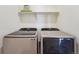 This laundry room features a side-by-side washer and dryer with a shelf at 2226 Monte Vista St, Fort Lupton, CO 80621
