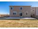 Backyard view of home, featuring a sliding glass door and fenced lawn at 579 Jewel St, Brighton, CO 80603