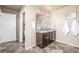 Bathroom featuring a double vanity with dark cabinets, tiled floor, and a view into the toilet room at 579 Jewel St, Brighton, CO 80603