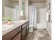 Bathroom with dual sinks, tiled floors, and a shower-tub combination at 579 Jewel St, Brighton, CO 80603