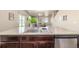 Kitchen island sink overlooks the living room, with sleek stainless steel dishwasher and dark wood cabinets at 579 Jewel St, Brighton, CO 80603