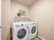 Laundry area with a shelf and decorations above the white washer and dryer at 579 Jewel St, Brighton, CO 80603