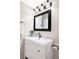 Bathroom vanity with white cabinets, black faucet and mirror, and bright lighting at 8856 W Prentice Ave, Littleton, CO 80123