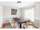 Dining room showcasing a modern table, six chairs, updated lighting, and a large window with sheer curtains at 8856 W Prentice Ave, Littleton, CO 80123