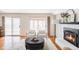 Inviting living room with a white brick fireplace, sleek hardwood floors, and sliding glass doors to a sunroom at 8856 W Prentice Ave, Littleton, CO 80123