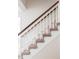 Carpeted staircase with white railings and a wooden handrail at 8856 W Prentice Ave, Littleton, CO 80123