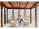 Bright sunroom with wooden ceiling, floor-to-ceiling windows, and comfortable wicker seating, offering a relaxing space at 8856 W Prentice Ave, Littleton, CO 80123