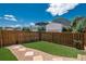 Backyard featuring a lawn with artificial turf, rock border, stone walkway, and wooden fence at 9781 Dunning Cir, Highlands Ranch, CO 80129