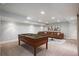 Finished basement with a pool table, a brown sectional sofa, and a decorative rug at 9781 Dunning Cir, Highlands Ranch, CO 80129