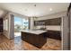 Open-concept kitchen with island, stainless appliances, modern lighting, and sliding glass doors to the backyard at 9781 Dunning Cir, Highlands Ranch, CO 80129