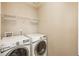 Efficient laundry room equipped with modern, white front-loading washer and dryer at 9781 Dunning Cir, Highlands Ranch, CO 80129