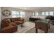Spacious living room area with a comfortable brown couch, a foosball table, and plenty of natural light at 9781 Dunning Cir, Highlands Ranch, CO 80129