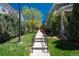 Tree-lined sidewalk leading to the house with lush lawn and manicured landscaping at 9781 Dunning Cir, Highlands Ranch, CO 80129