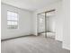 Bright bedroom featuring carpeted floors, a large window for natural light, and a mirrored closet, enhancing the room's spaciousness at 1699 S Trenton St # 174, Denver, CO 80231