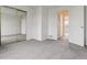 Bright bedroom with mirrored closet doors, gray carpet, and white walls, creating a serene and inviting space at 1699 S Trenton St # 174, Denver, CO 80231