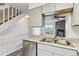 Renovated kitchen with stainless steel sink and view to adjacent living area with fireplace and balcony access at 1699 S Trenton St # 174, Denver, CO 80231