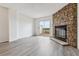 Living room featuring wood-look floors, stone fireplace and sliding glass doors opening to the outdoor deck at 1699 S Trenton St # 174, Denver, CO 80231