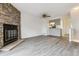 Open-concept living space with stone fireplace, wood-look floors, a ceiling fan, and a view of the modern kitchen at 1699 S Trenton St # 174, Denver, CO 80231