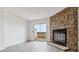 Light-filled living room with wood-look floors, a cozy stone fireplace, and sliding glass doors leading to the deck at 1699 S Trenton St # 174, Denver, CO 80231