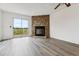 Bright living room with wood-look floors, a stunning stone fireplace, and sliding glass doors to an outdoor deck at 1699 S Trenton St # 174, Denver, CO 80231