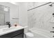 Bright bathroom features modern vanity, marble-look tile surround, and tub with shower combo at 11383 Autumn Moon St, Littleton, CO 80125