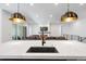 A long island countertop and deep sink sit between pendant lights at 11383 Autumn Moon St, Littleton, CO 80125