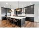Modern kitchen with dark cabinets, white countertops, and a spacious island with seating at 11383 Autumn Moon St, Littleton, CO 80125