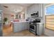 Charming kitchen with stainless steel appliances, light gray cabinets and open layout at 421 Elati St, Denver, CO 80204