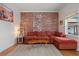 Cozy living room featuring an exposed brick wall, plush sectional sofa, and bright natural light at 421 Elati St, Denver, CO 80204