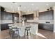 Elegant kitchen boasts modern cabinetry, a large island with bar seating, and stylish pendant lighting at 3128 Bivouac Pt, Castle Rock, CO 80108