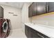 Functional laundry room equipped with cabinetry, a sink, and modern, high-end washer and dryer at 3128 Bivouac Pt, Castle Rock, CO 80108