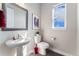 Well-lit powder room featuring a pedestal sink, modern fixtures, and stylish decor at 3128 Bivouac Pt, Castle Rock, CO 80108