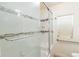 Bathroom featuring a tiled shower with glass doors, grab bars and window at 4849 Lincoln St, Denver, CO 80216