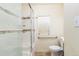 Bathroom featuring a shower with glass doors, grab bars, tiled walls and a window at 4849 Lincoln St, Denver, CO 80216