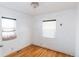 Bedroom featuring hardwood floors, two windows, base-molding and a ceiling light at 4849 Lincoln St, Denver, CO 80216