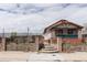 Charming home exterior featuring a brick fence, front porch, and well-maintained landscaping at 4849 Lincoln St, Denver, CO 80216