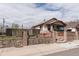 View of the property's exterior featuring manicured landscaping, secure fencing and stone accents at 4849 Lincoln St, Denver, CO 80216