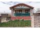 Charming home featuring a well-maintained front yard, secure fencing, and a welcoming porch at 4849 Lincoln St, Denver, CO 80216