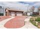 Detached two-car garage with a stone facade and large red-stamped concrete driveway at 4849 Lincoln St, Denver, CO 80216