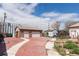 Detached two-car garage with a stone facade and large driveway; backyard has grass area at 4849 Lincoln St, Denver, CO 80216