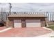 Detached two-car garage with a stone facade, red-stamped concrete driveway, and a shingled roof at 4849 Lincoln St, Denver, CO 80216