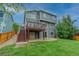 Two-story home featuring a deck, lush green backyard, and partial fence at 9884 Sydney Ln, Highlands Ranch, CO 80130