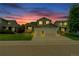 Charming two-story home boasts a three-car garage, lush lawn, and well-maintained landscaping at dusk at 9884 Sydney Ln, Highlands Ranch, CO 80130